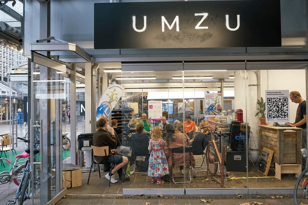 Eine Gruppe von Menschen sitzt in einem Stuhlkreis im UMZU-Laden im Hanseatenhof.