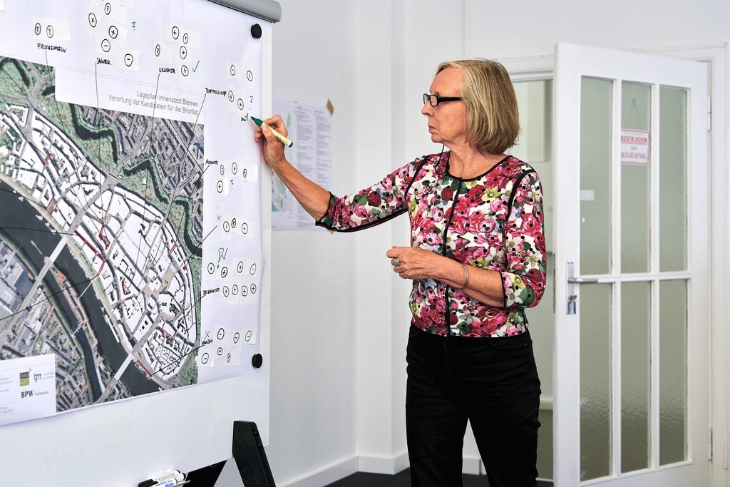 Frau beschriftet Plan der Bremer Innenstadt während eines Workshops